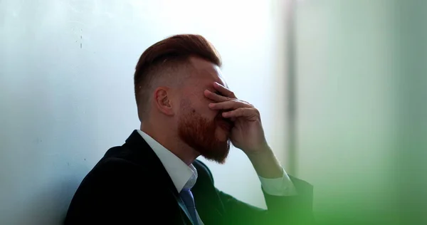 Frustrated business man sitting on floor feeling despair