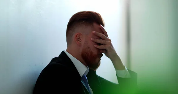 Frustrated business man sitting on floor feeling despair