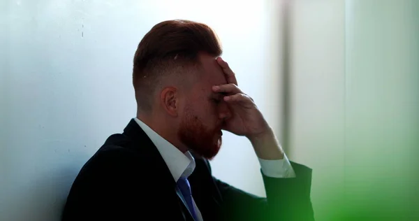 Frustrated business man sitting on floor feeling despair