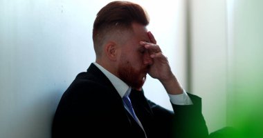 Yerde oturan adam depresyonda.