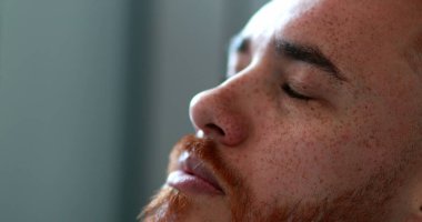 Tanrı 'dan yardım isteyen adam yukarı bakıyor, kızıl saçlı adam derin düşüncelere dalmış ve maneviyatla gözlerini kapıyor.