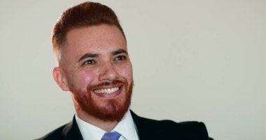 Mutlu adam gülümsüyor. İyi haberler aldığında seviniyor. Hoş sürpriz bir gülümseme, takım elbiseli kızıl saçlı adam.