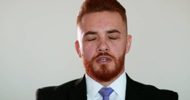 Mutlu adam gülümsüyor. İyi haberler aldığında seviniyor. Hoş sürpriz bir gülümseme, takım elbiseli kızıl saçlı adam.