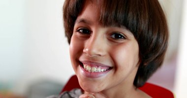 Yakışıklı melez çocuk kameraya bakıyor.