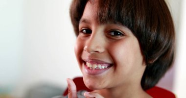 Yakışıklı melez çocuk kameraya bakıyor.