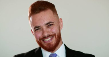 Yakışıklı, rahatlatıcı, duygusal portresi olan, iş elbisesi giyen, kızıl saçlı bir adam.