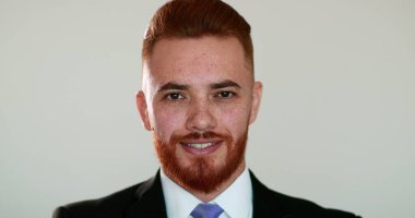 Yakışıklı, rahatlatıcı, duygusal portresi olan, iş elbisesi giyen, kızıl saçlı bir adam.