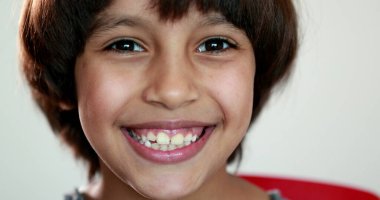 Gülümseyen yakışıklı çocuk portresi. Farklı etnik çeşitlilikte melez genç bir çocuk.