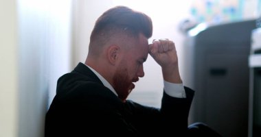 Düşünceli iş adamı hayal kırıklığı içinde yerde oturmuş çözüm arıyor.