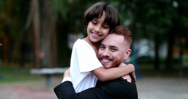 Ebeveyn ve çocuk kucaklaşır ve kucaklaşır. Baba ve genç çocuk farklı etnik çeşitlilikte sevgi ve özen, otantik