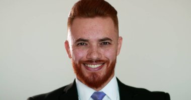 Kameraya gülümseyen kızıl saçlı adam portresi. İş adamı takım elbiseli gülümseme