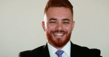 Spontane gerçek hayat gülümsemesi ve kahkahası. Yakışıklı kızıl saçlı, gülümseyen ve gülen bir portre, otantik mutlu insan.