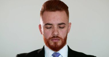 Kızıl saçlı yakışıklı gözlerini kapatıp rahatlamaya ve meditasyon yapmaya çalışıyor.