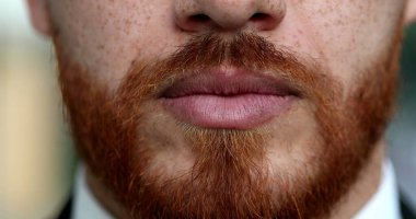 Ciddi kızıl saçlı adam dudakları ve ağzı kızıl sakallı.