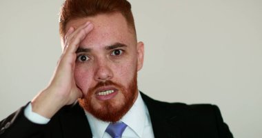 İnançsız duygularla karışık insan tepkisi. Şok yüzünden yüzünü saklayan biri.