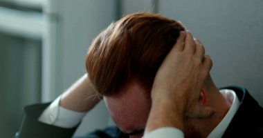 Düşünceli iş adamı hayal kırıklığı içinde yerde oturuyor.