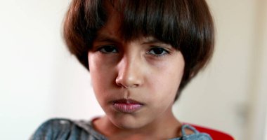 Kamera portresine bakan melez bir genç çocuk. Etnik çeşitliliğe sahip öfkeli bir çocuk.