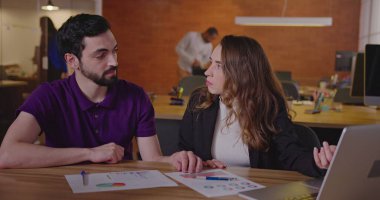 İş yerindeki genç ofis çalışanları sonuçları ve planları gözden geçiriyorlar. Erkek ve kadın personel planlama işi