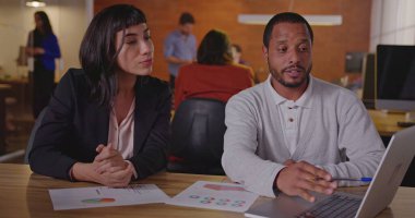 Çeşitli meslektaşlar işi tartışıyor. Latin bir Latin kadın çalışana yeni işi açıklayan siyah bir çalışan.