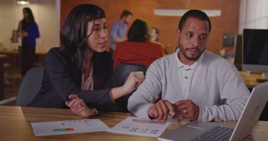 Çeşitli meslektaşlar işi tartışıyor. Latin bir Latin kadın çalışana yeni işi açıklayan siyah bir çalışan.