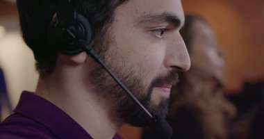 Erkek çalışan, kulaklıkla müşteriyle konuşuyor. Kulaklıkla pazarlama kavramı