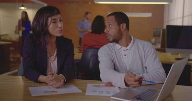 Çeşitli meslektaşlar işi tartışıyor. Latin bir Latin kadın çalışana yeni işi açıklayan siyah bir çalışan.