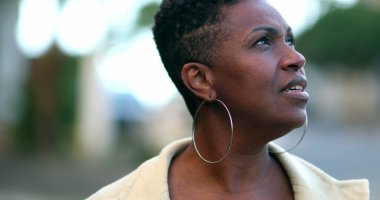 Dışarıda yürüyen endişeli Afrikalı kadın. Siyahi insan düşüncelerini düşünüyor.