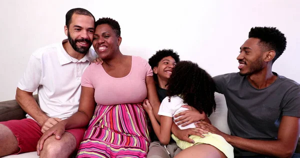 African family hugging in home sofa. Mixed race black parents and children embrace, love and affection