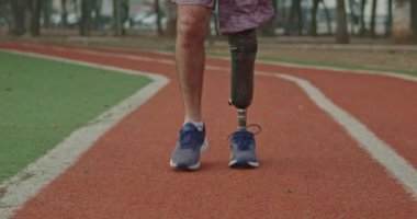 One disabled athlete with prosthetic leg walks forward