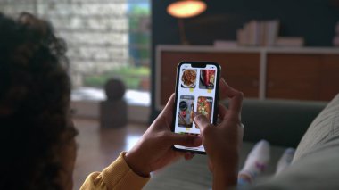 Hand closeup browsing food online store on cellphone app. Person scrolling screen choosing meal on menu
