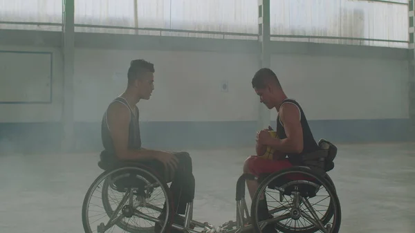 Two disabled basketball athletes on wheelchairs talking