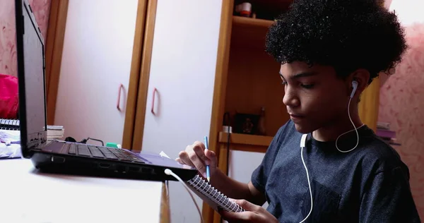 Boy Doing Homework Home Browsing Laptop Writing Notes Looks Camera —  Fotos de Stock