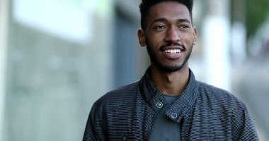 Kendinden emin Afrikalı genç adam gülümsüyor.