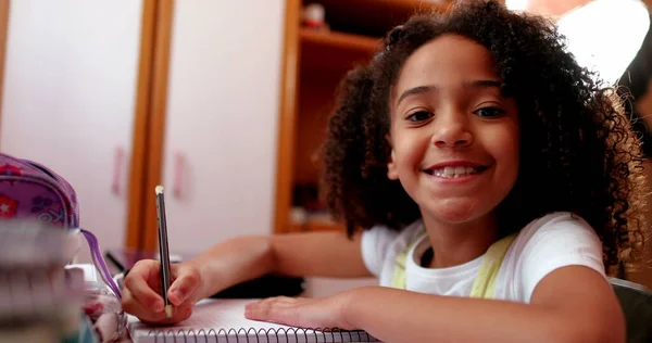 Cute Schoolgirl Smiling Camera While Doing Homework — Stock Fotó