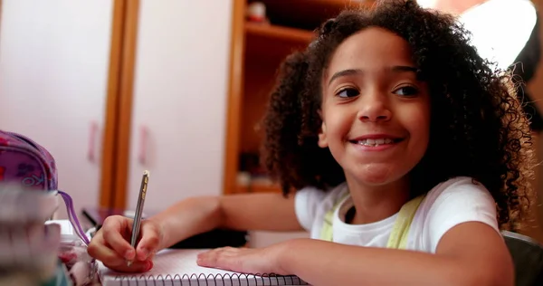 Cute Schoolgirl Smiling Camera While Doing Homework — Φωτογραφία Αρχείου