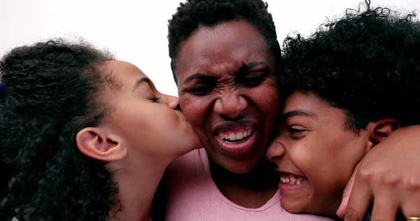 Children hugging and kissing mother. Black African ethnicity love and affection