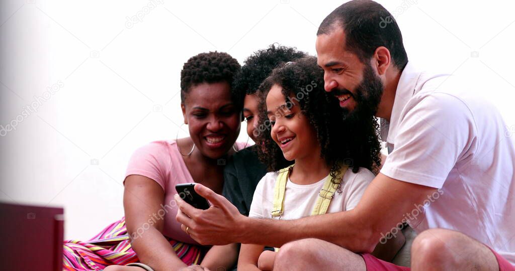 Family looking at cellphone together. Parents and children gathered around smartphone