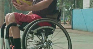 One disabled basketball player playing ball outside. Closeup of paraplegic person on wheelchair action motion. Sport and disability concept