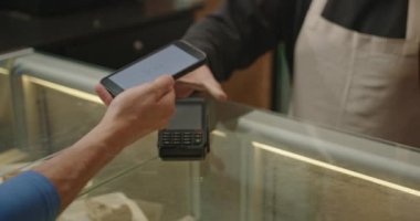 Temassız ödemeyle yakın çekimde telefonla ödeme yapmak. Bir restoranda NFC teknolojisi. Bir kahve dükkanında cep telefonu ödemesi.