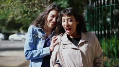 İki bayan arkadaş el ele tutuşarak dedikodu yapıyorlar. Arkadaş dedikoduyu paylaşıyor