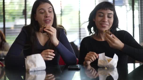 Two Women Eating Burgers Lunch Female Girlfriends Taking Bite Hamburgers — Αρχείο Βίντεο