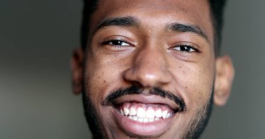 Dost canlısı siyah Afrikalı adam gülümseyen kameraya bakıyor