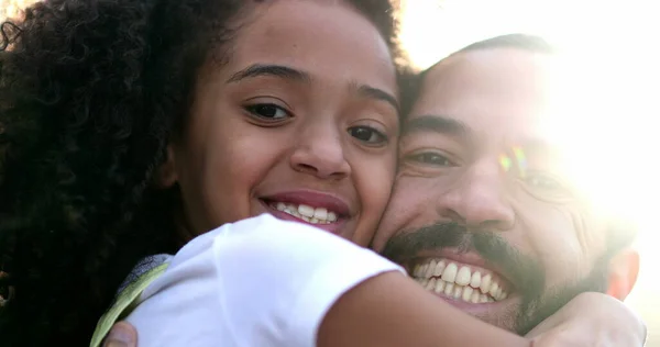 Family love and affection. Father and daughter hugging each other with lens-flare