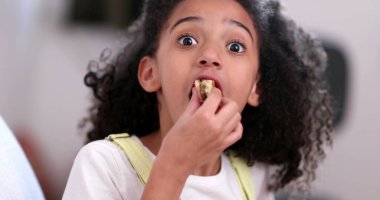 Hamburger yiyen küçük bir kız. Hamburger yiyen çocuk.