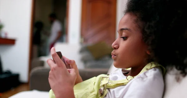 Little Black Girl Using Smartphone Device Home Sofa African Ethnicity — Stockfoto