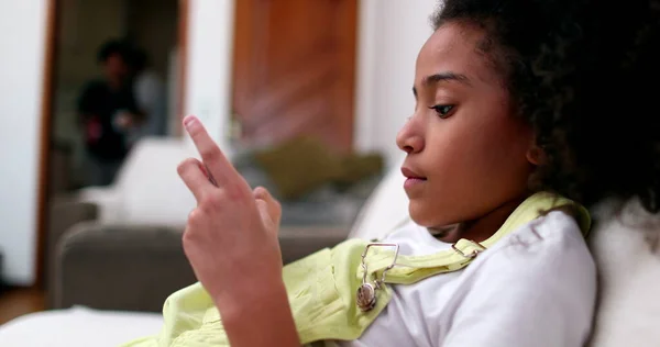 Klein Zwart Meisje Met Behulp Van Smartphone Apparaat Thuis Bank — Stockfoto