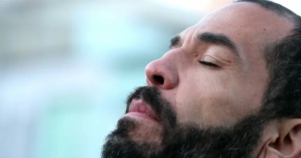 Hispanic man closing eyes in meditation. 40 year old person eyes closed being mindful