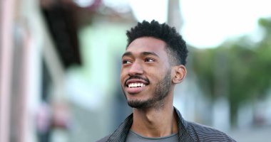 Kaldırımda yürüyen melez bir genç adam. Kendinden emin Afrikalı adam.