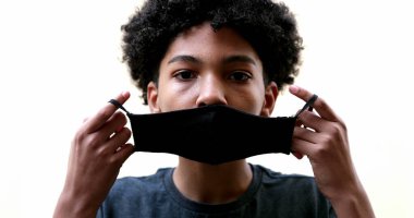 Karışık ırk çocuğu covid-19 yüz maskesi takıyor.