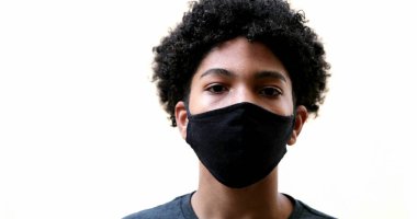Mixed race kid putting covid-19 face mask on